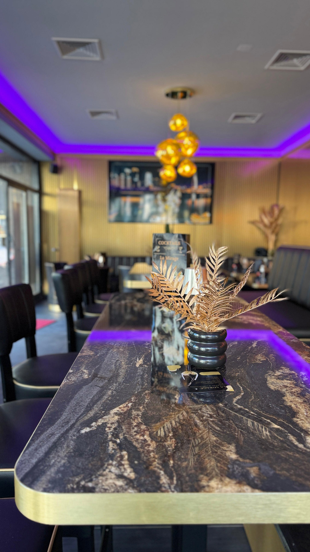 Ein elegantes Restaurant mit goldenen Akzenten, moderner Beleuchtung und dekorativen Pflanzen